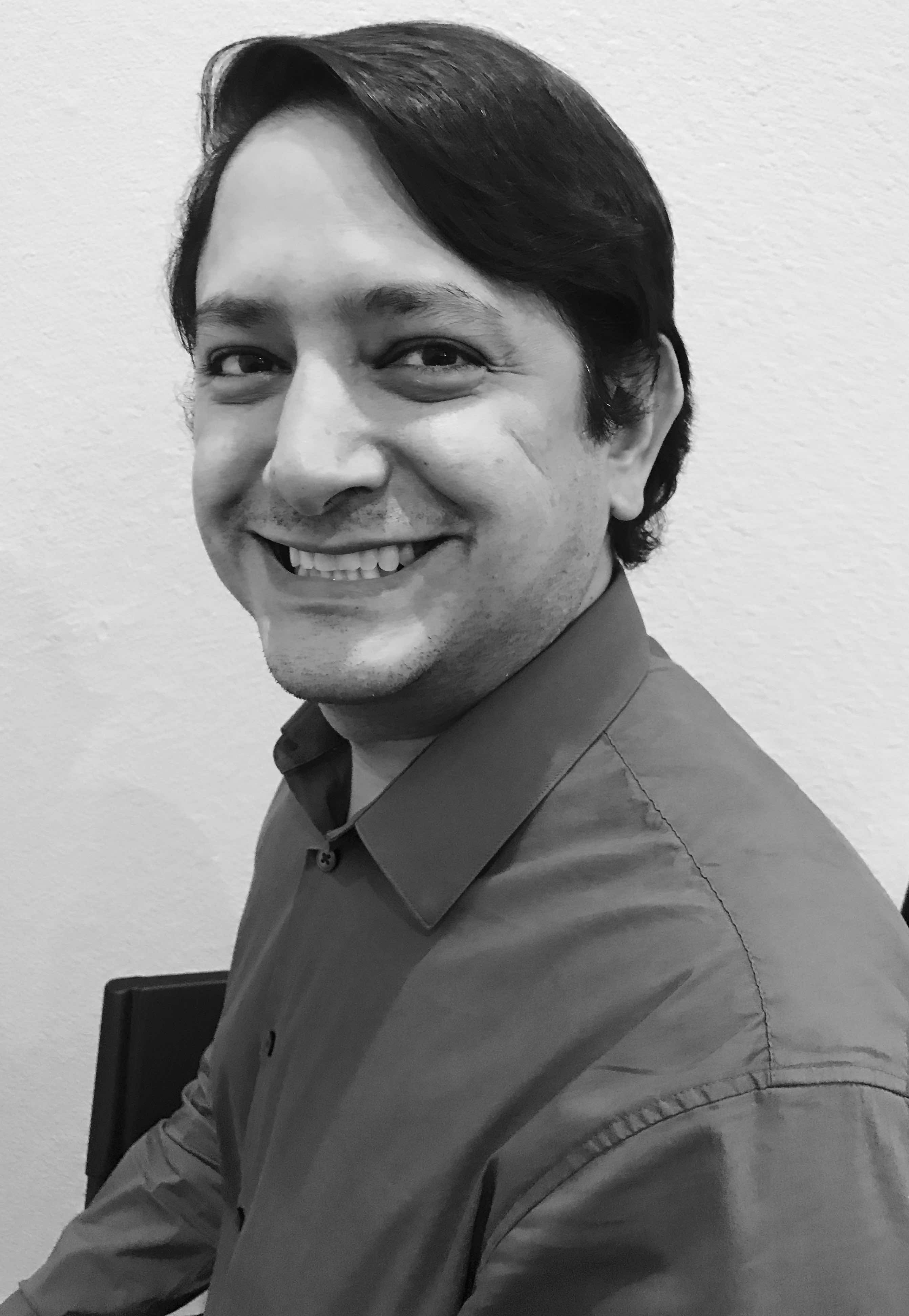 Marcus Couto, photographed in black and white, turning toward the camera.